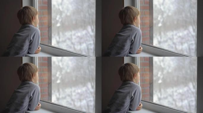 一个小男孩透过窗户看着大雪，等待圣诞节的到来。慢动作镜头