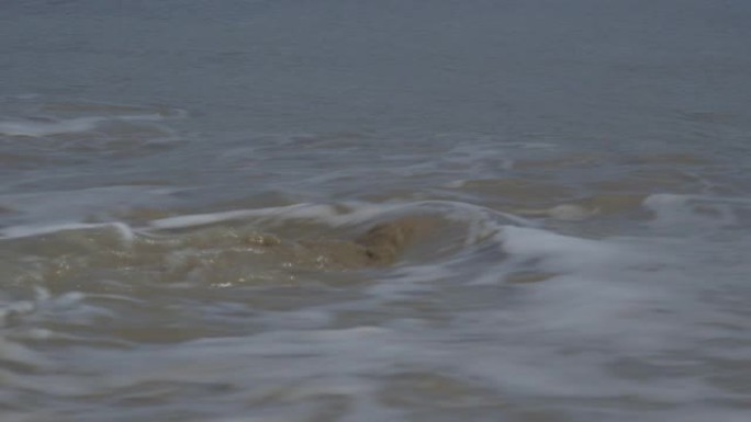 海浪摧毁海滩上的沙堡