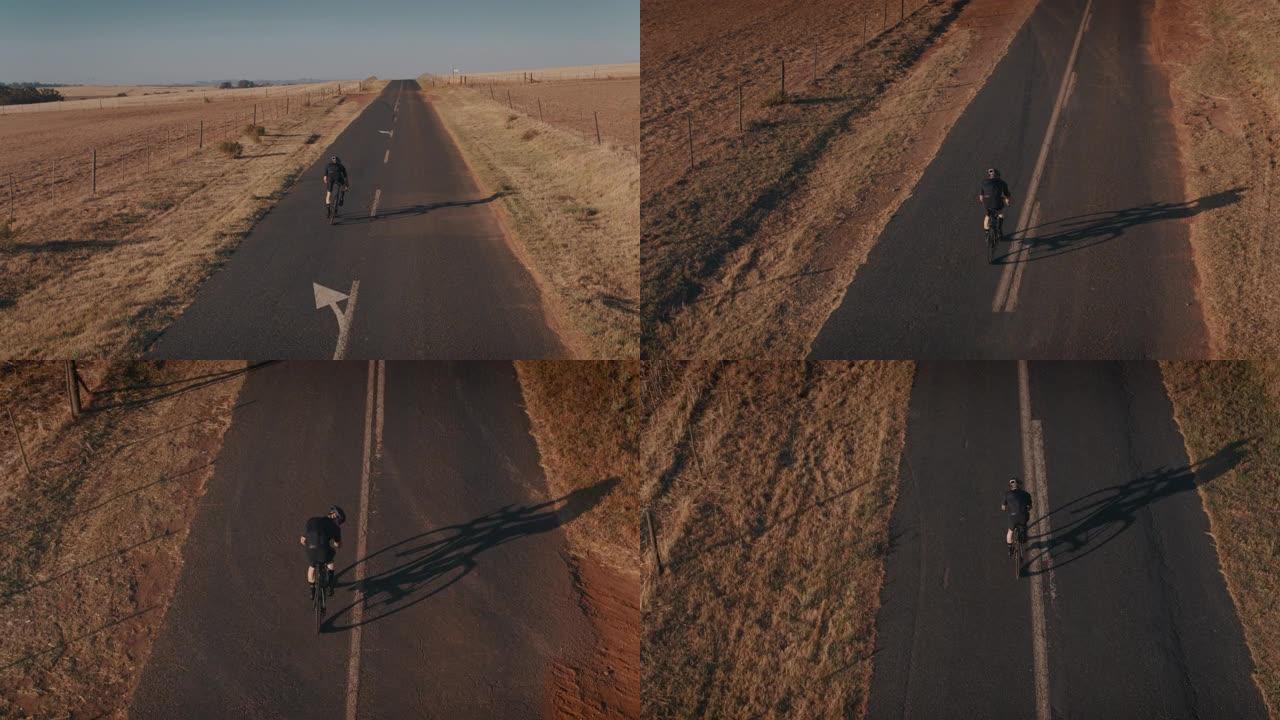 运动员在一条漫长的乡村公路上坡骑自行车