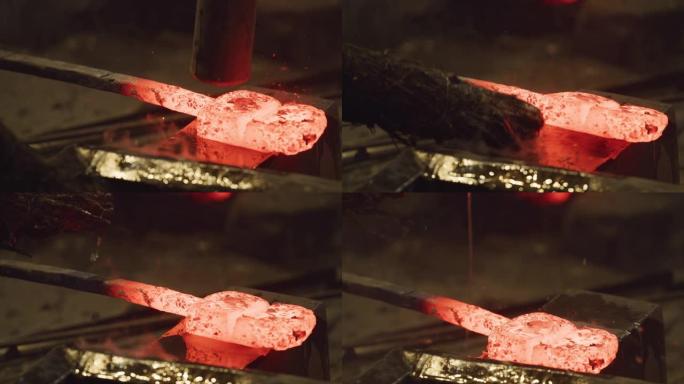 在锤打发光的锭之前，水被溅到砧上。日本传统的伪造方法，用于创造武士武士刀哈蒙。日本工艺文化。