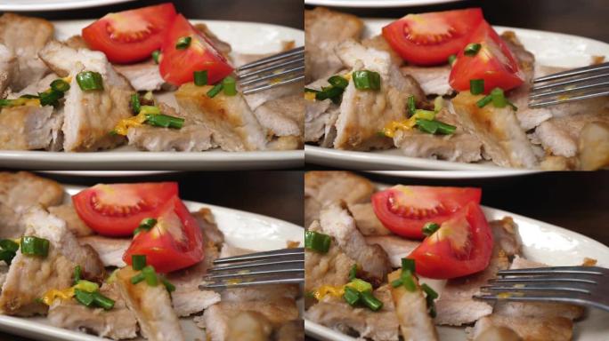用西红柿和葱和叉子切成肉块，在盘子上旋转
