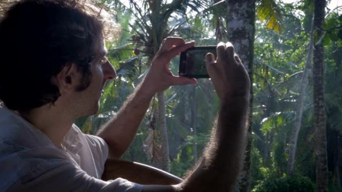 多莉拍摄了一名中年男子在郁郁葱葱的丛林中拍照