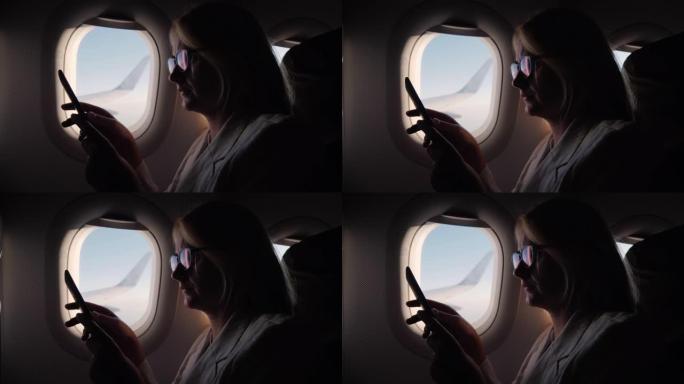 年轻女子的侧视图在飞行中阅读电子书