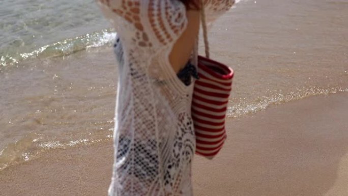 巴雷富特宁静的女人走在沙滩上，留下脚印