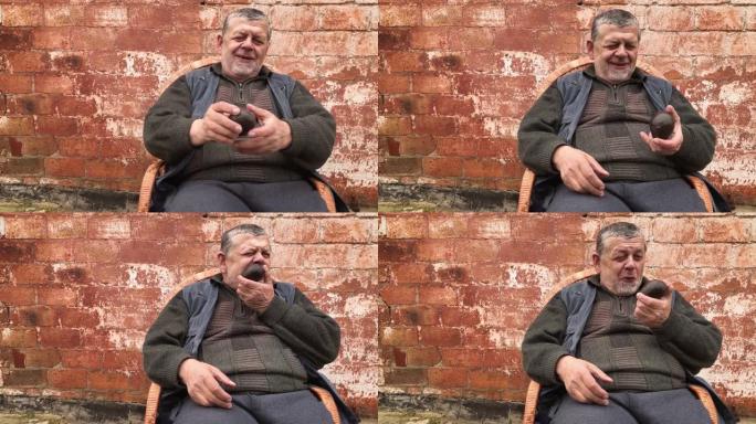 乌克兰高级农民坐在柳条椅上，一生中第一次仔细检查鳄梨哈斯
