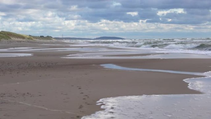 在海里破浪。泡沫在海滩附近坠落的危险海浪，即将来临的潮汐