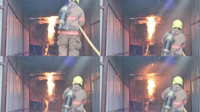 消防员穿着消防服走进消防训练室，在消防站慢动作喷水后视图。消防员生涯，训练消防演练理念。