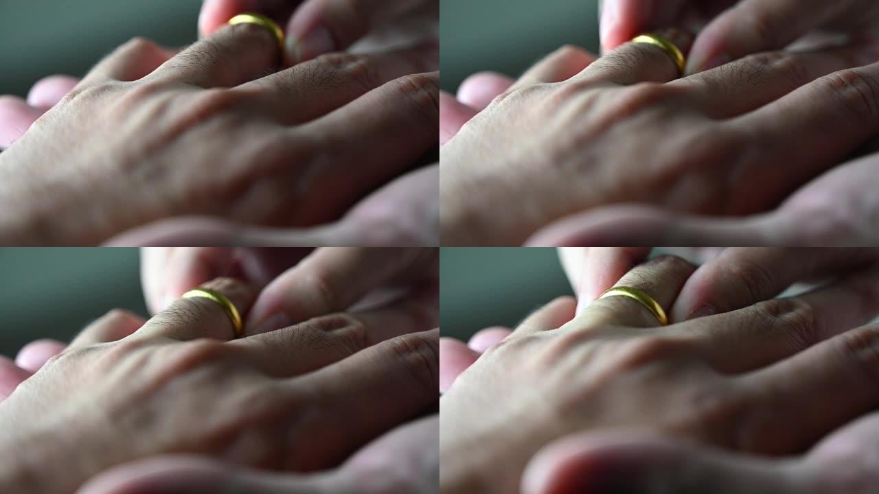 特写亚洲女人把结婚戒指戴在新娘的亚洲男人手指上。带戒指的结婚手。婚礼和婚姻概念。