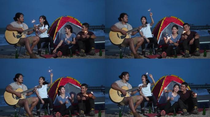 一群年轻的亚洲朋友，在日落场景中露营唱歌喝啤酒