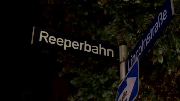 Reeperbahn街道标志在夜间照明和来自德国汉堡的巡逻警车的警笛反射中