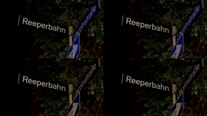 Reeperbahn街道标志在夜间照明和来自德国汉堡的巡逻警车的警笛反射中