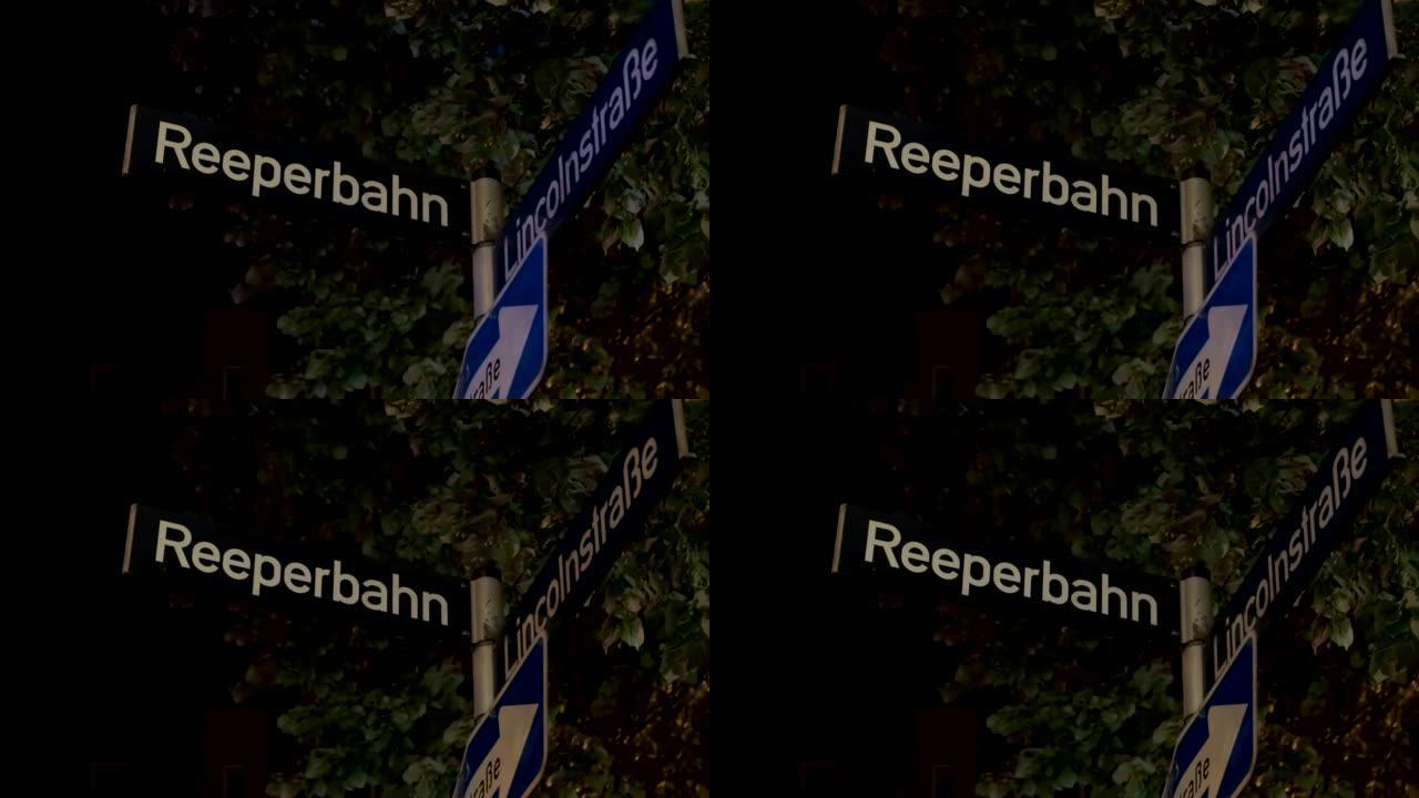 Reeperbahn街道标志在夜间照明和来自德国汉堡的巡逻警车的警笛反射中