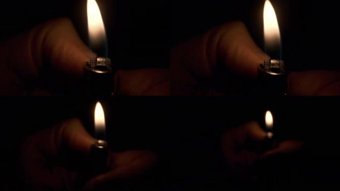 人手中的烧伤较轻。黑暗中来自打火机的光线。