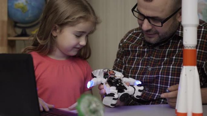 女学生和老师在现代教室组装机器人。爸爸和女儿在家组装机器人。教育科学，技术儿童，编程电子机器人学校课