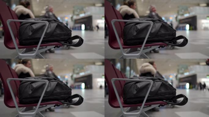 机场候机楼等候区长凳上的旅行背包，带椅子