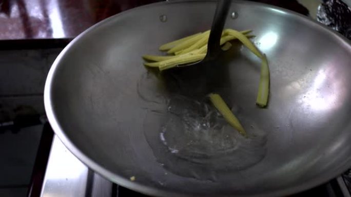 平底锅里煮的玉米宝宝。把它铲起来。