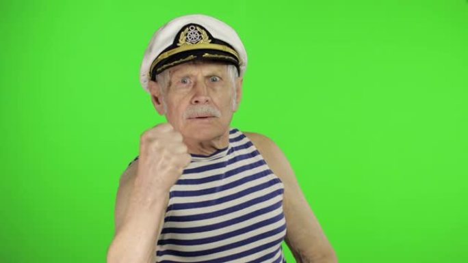 年长的水手很生气，露出拳头。色度关键背景上的水手