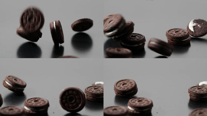 在黑暗背景下慢动作掉落的巧克力饼干和奶油的特写镜头