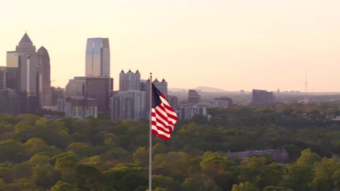亚特兰大航空v265在美国国旗周围低空飞行，日落时可以看到城市景观