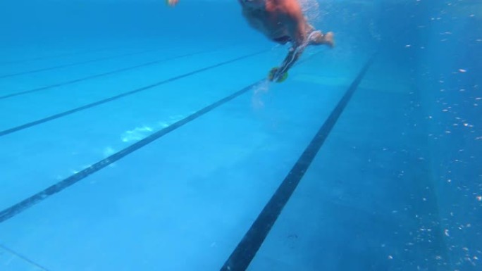 高级男子在游泳池中以自由泳游泳