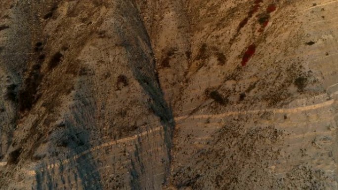 日落时巨大山岩美景的飞行航拍画面。