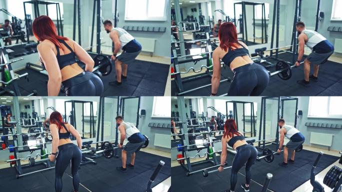 一对运动夫妇在健身房接受艰苦训练时的后视图。