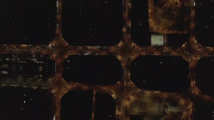 空中: 巴塞罗那头顶无人机拍摄夜间典型的城市街区，带有美丽的城市交通信号灯 [4K]
