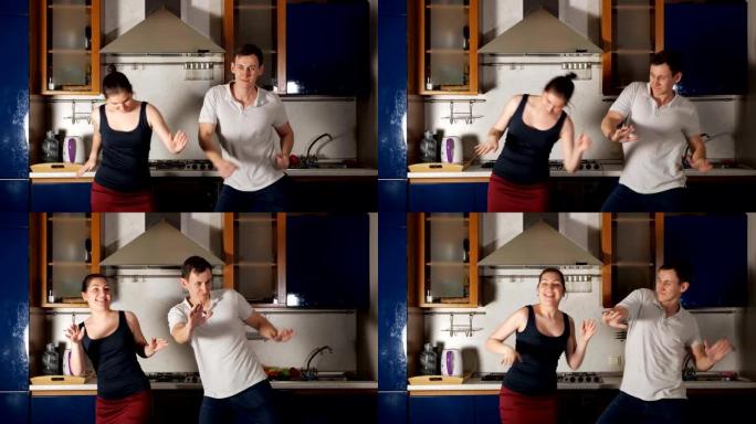 快乐的男人和女人跳舞，跳起来在厨房玩得开心