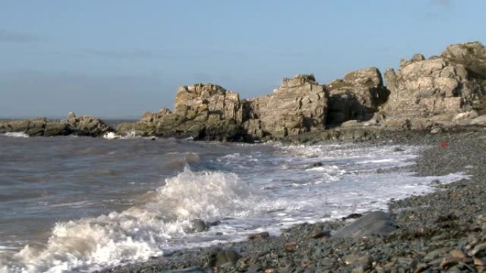 在一个明亮的大风天，岩石苏格兰海滩上的海浪