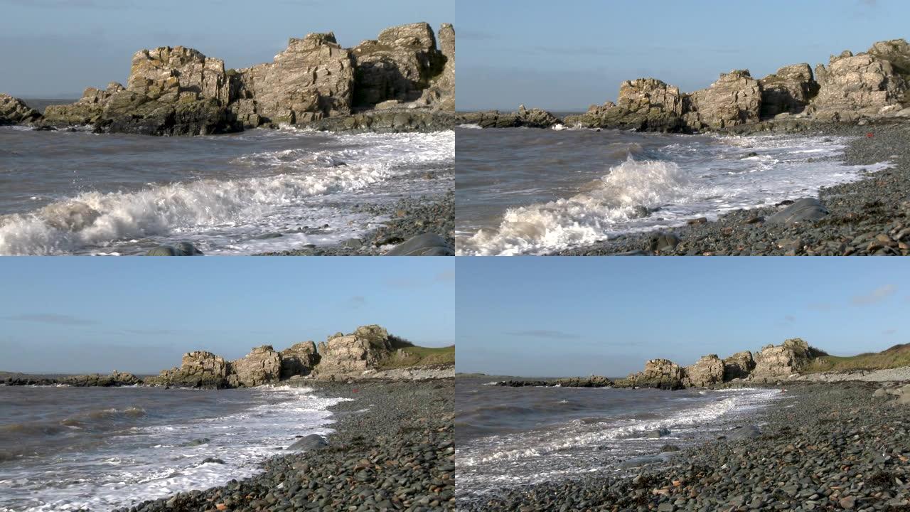 在一个明亮的大风天，岩石苏格兰海滩上的海浪