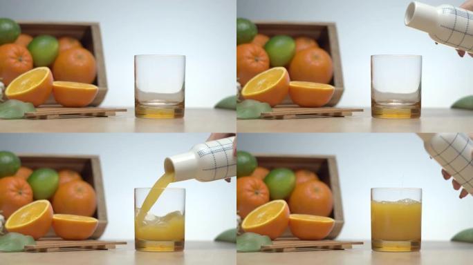 刚将橙汁倒入厨房桌子上的玻璃杯中