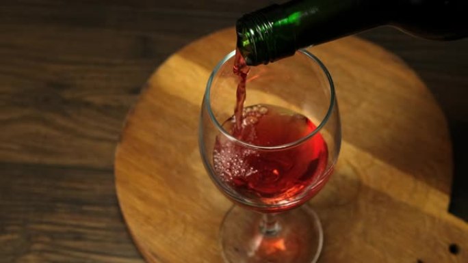 熟练的侍酒师将红酒从瓶子倒入玻璃杯中。