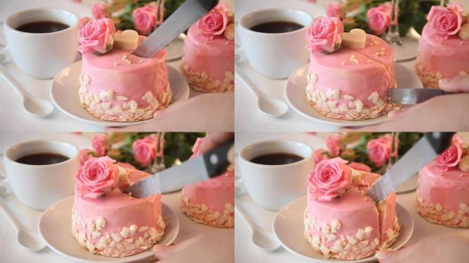 女人用粉色釉切迷你小蛋糕，装饰美丽的玫瑰。背景上的一杯咖啡