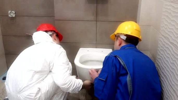 专业工人男士在新现代浴室悬挂重型马桶平底锅