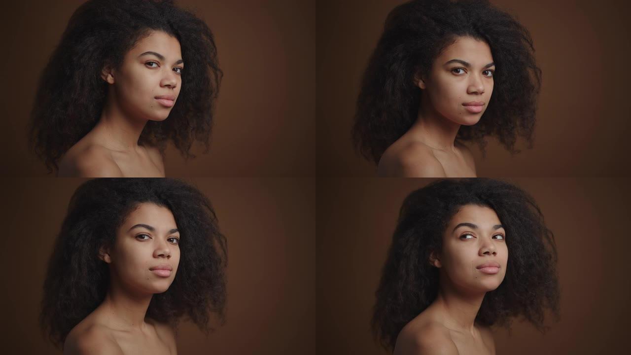 裸体非洲裔美国女孩的侧写肖像，看着棕色背景