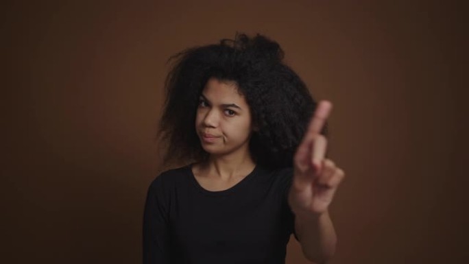 恼怒的非洲裔美国女孩指责并禁止用手指指着相机