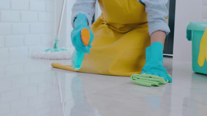 年轻的亚洲妇女打扫房子她的地板去除地板上的污渍借助喷雾保持概念的特殊清洁