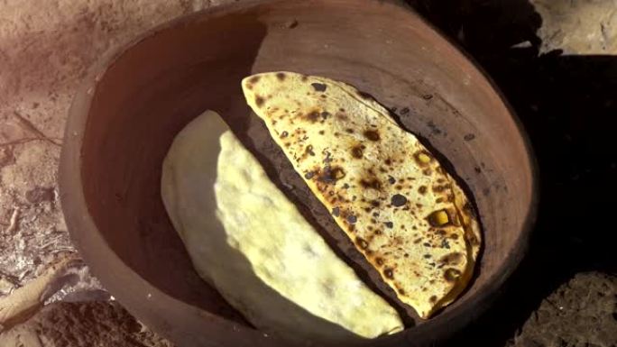 传统的东方菜肴，由在火上的粘土锅中烘烤的面团制成