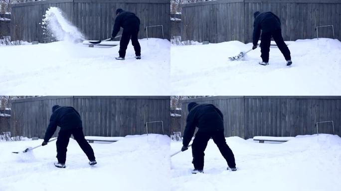雪夜后工作。在一个寒冷的下雪的早晨，男人用铲子从院子里除雪