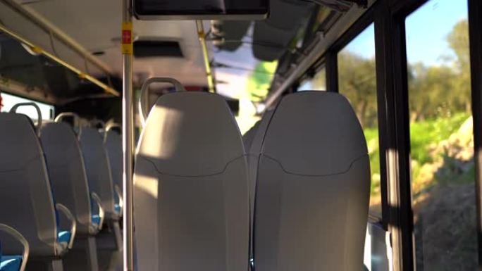 沿着乡村街道行驶的空公交车内部。阳光照明车厢，欧洲品质的舒适座椅。驾驶巴士概念