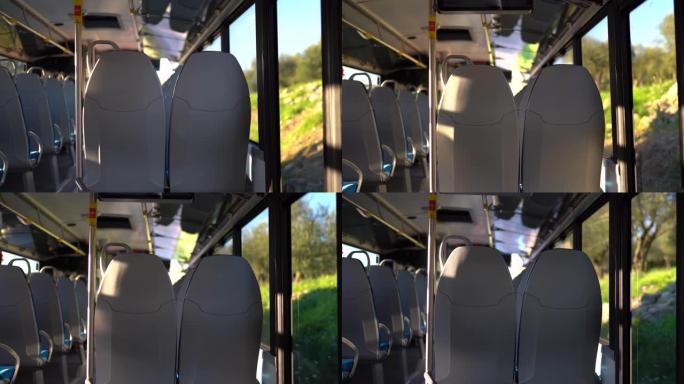 沿着乡村街道行驶的空公交车内部。阳光照明车厢，欧洲品质的舒适座椅。驾驶巴士概念