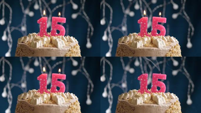 蓝色背景上有15个数字粉色蜡烛的生日蛋糕。蜡烛吹灭了。慢动作和特写视图