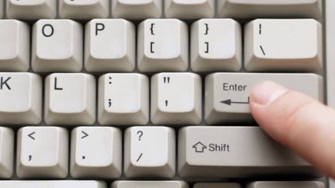 男性手指按下白色键盘上的输入按钮。慢动作和宏观视图