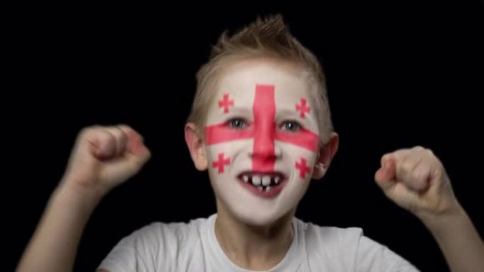 快乐男孩为他最喜欢的乔治亚队的胜利而高兴。脸上涂着民族色彩的孩子。