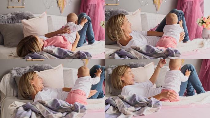昏昏欲睡的女婴在午睡前与母亲在床上玩耍