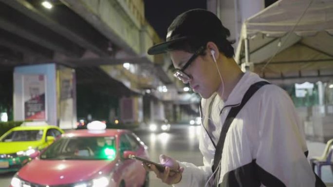 晚上，男人使用智能手机等待出租车或Uber