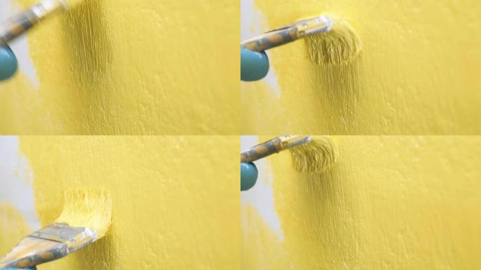 刷子在白色墙壁上上下移动，并将其涂成黄色。壁画概念。慢动作和特写视图
