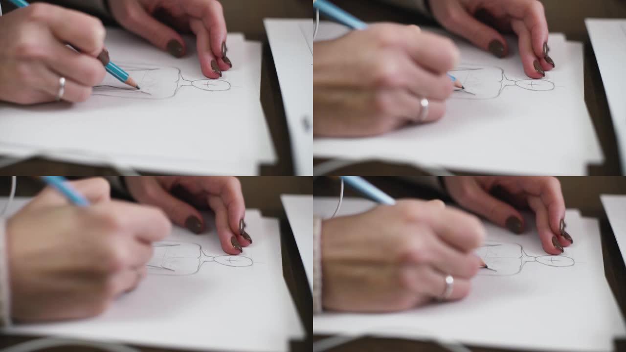 时装设计师为服装素描绘制模型。女裁缝的手在她的工作室的纸上绘制图案