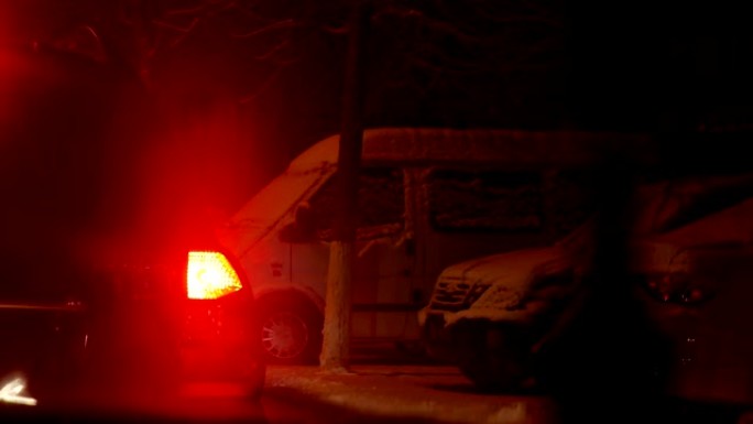 夜间路灯下积雪覆盖的车辆