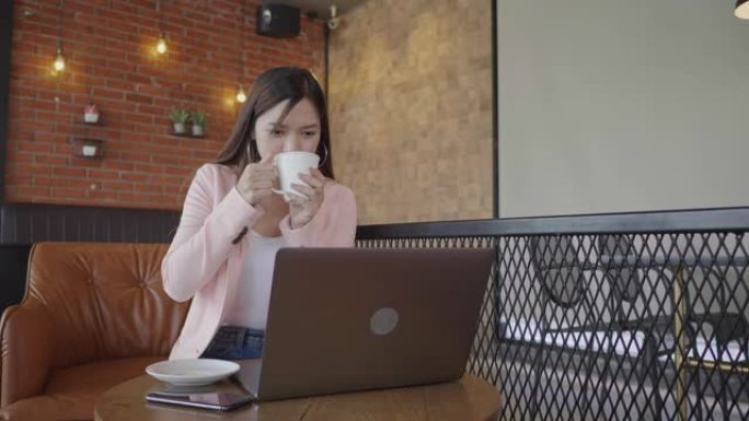 年轻女性自由职业使用电话和喝咖啡